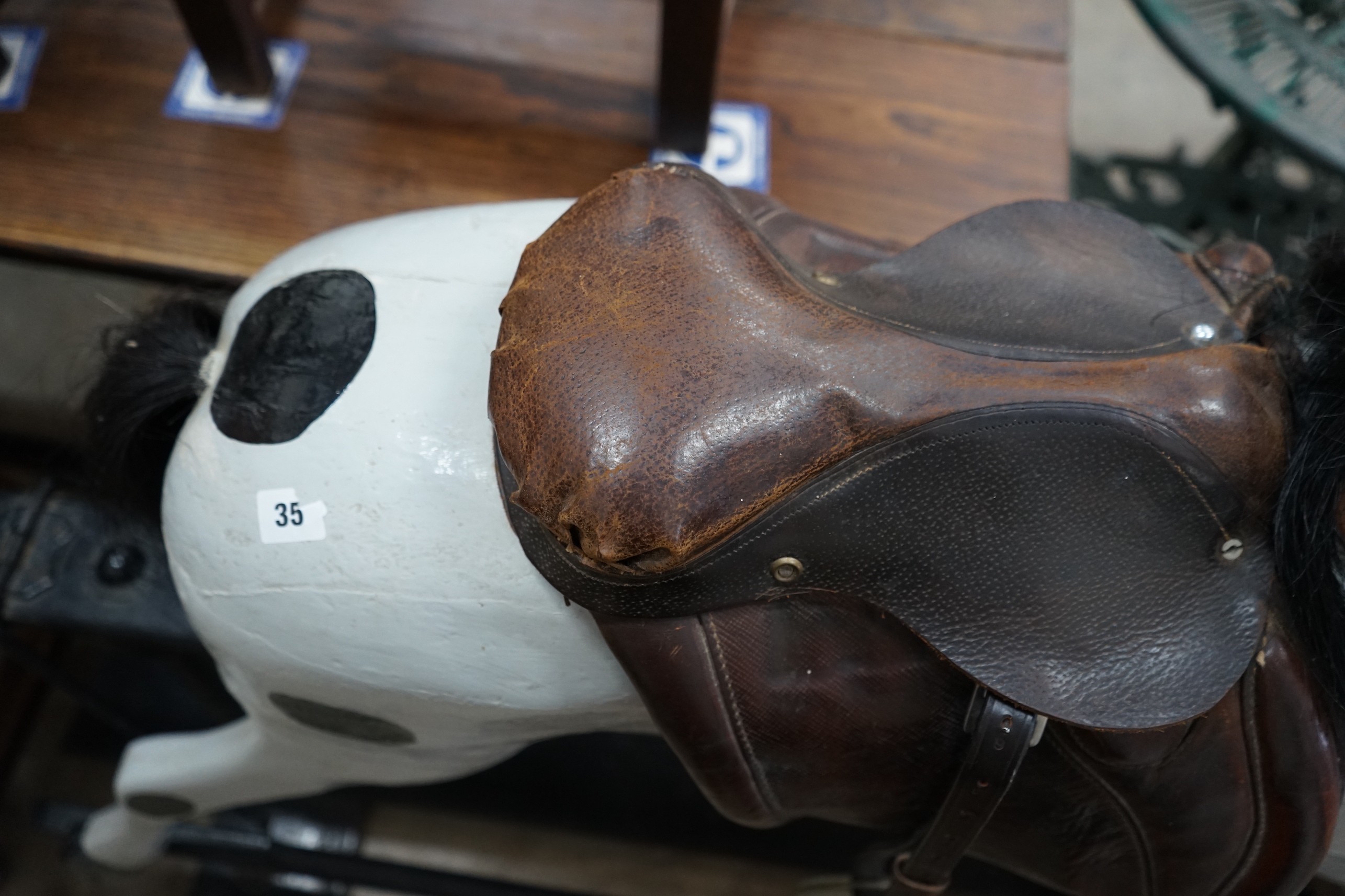 An early 20th century carved wood rocking horse on safety frame (re-painted), height 126cm